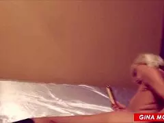 Fully grown up slender type of a woman wearing boots having fun with a fake penis
