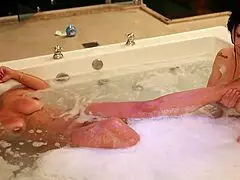 A bisexual lesbian couple enjoys a hot bath together.